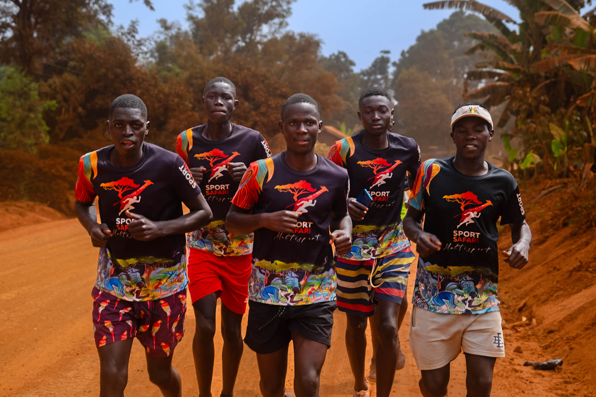 5 Ugandan boys running on a sand road